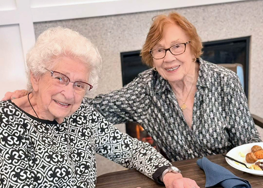 Two senior women dine together for dinner in the dining room at Vitalia North Royalton.