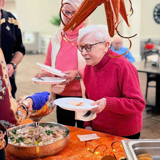 A senior woman at Vitalia North Royalton is served a delicious meal at a community event.